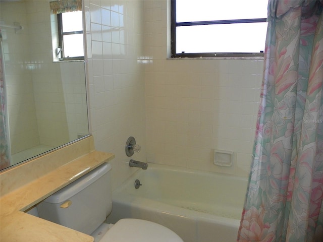 bathroom featuring toilet, plenty of natural light, and shower / tub combo with curtain