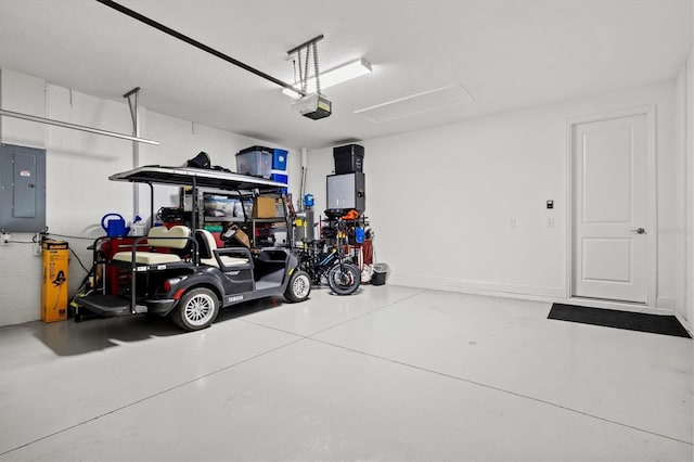 garage with concrete block wall, electric panel, and a garage door opener