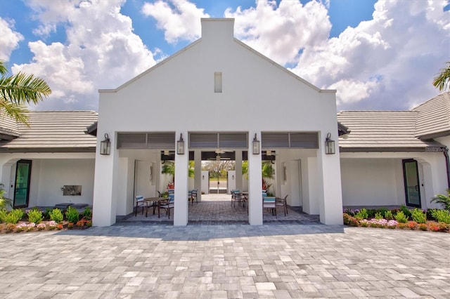 exterior space with a patio, a tile roof, and stucco siding