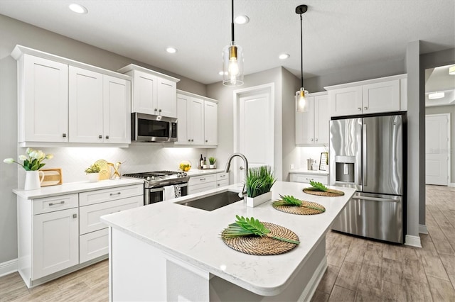 2720 Butterfly Jasmine Trl, Sarasota, FL 34240 - kitchen featuring appliances with stainless steel finishes, a sink, light wood-style flooring, recessed lighting, and a center island with sink
