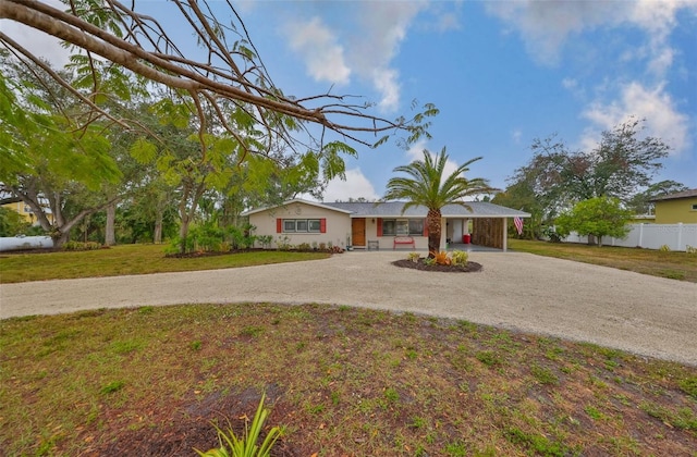 single story home with driveway, a front yard, and fence