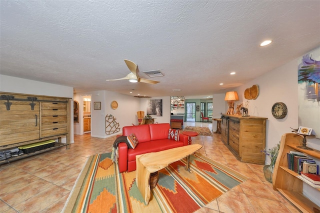 living room featuring light tile patterned floors, recessed lighting, visible vents, a ceiling fan, and a textured ceiling