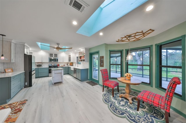 kitchen featuring a skylight, visible vents, stainless steel appliances, and light countertops