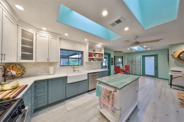 kitchen featuring a skylight, visible vents, decorative backsplash, appliances with stainless steel finishes, and a sink