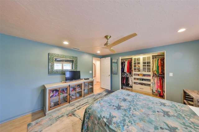 bedroom featuring recessed lighting, a closet, visible vents, a textured ceiling, and wood finished floors