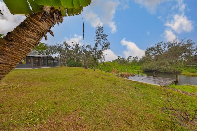 view of yard featuring a water view and a sunroom