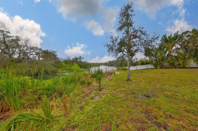 view of yard with a water view and fence