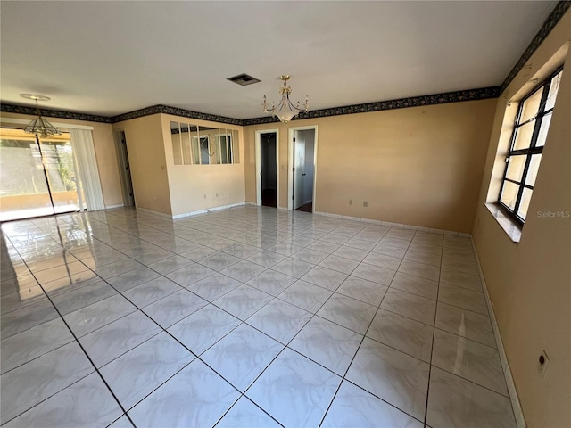 tiled empty room with visible vents, baseboards, and an inviting chandelier