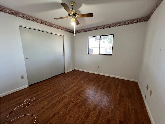 unfurnished bedroom featuring a ceiling fan, a closet, baseboards, and wood finished floors