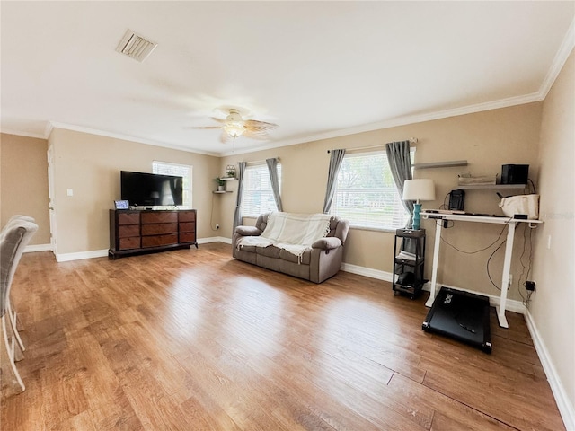 workout room featuring crown molding, baseboards, and wood finished floors