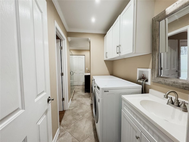 washroom with ornamental molding, light tile patterned flooring, a sink, and separate washer and dryer