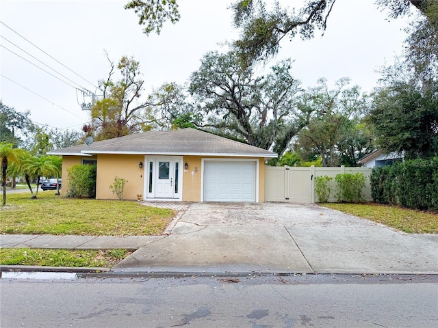 ranch-style house with stucco siding, an attached garage, a gate, driveway, and a front lawn