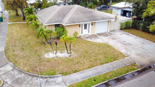 ranch-style house with a garage, concrete driveway, a front lawn, and stucco siding