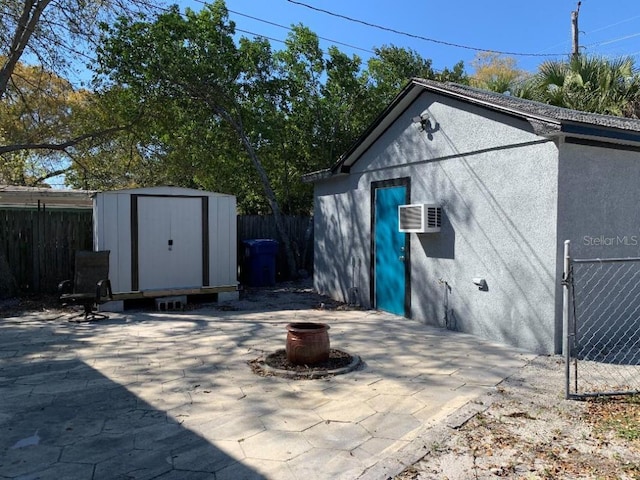 view of shed featuring a wall unit AC and a fenced backyard