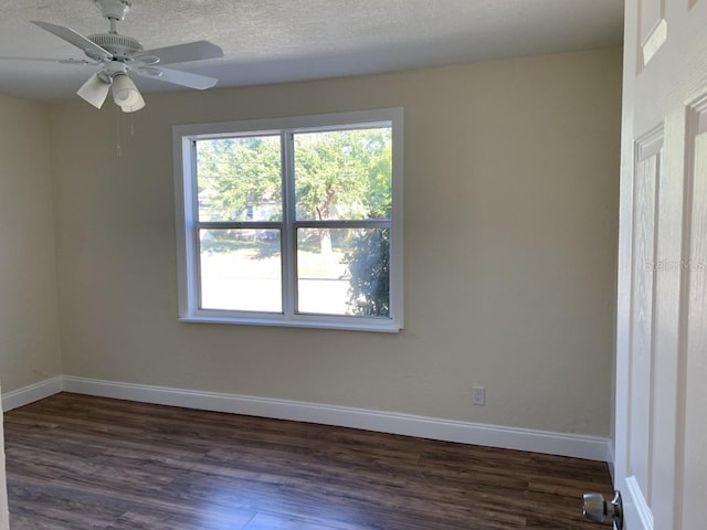 spare room with dark wood-style floors, ceiling fan, a textured ceiling, and baseboards