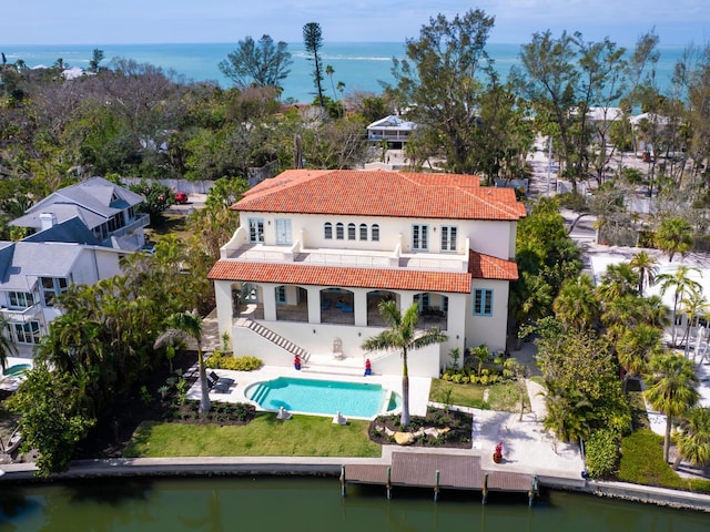 rear view of house featuring a balcony, a tiled roof, a water view, stairs, and a patio area