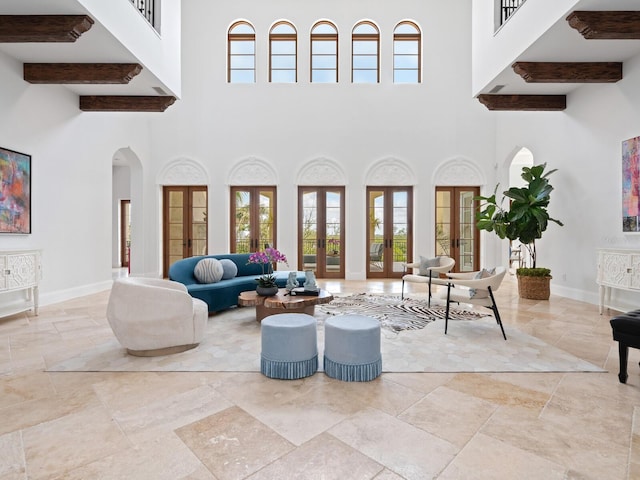 living area featuring arched walkways, french doors, a high ceiling, and baseboards