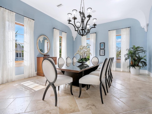 dining area featuring baseboards, an inviting chandelier, visible vents, and stone tile floors