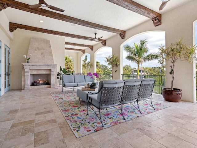 view of patio with ceiling fan and an outdoor living space with a fireplace