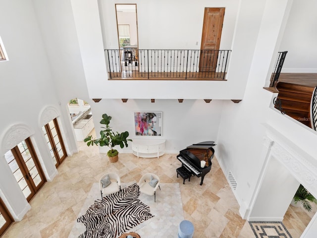 interior space with baseboards, plenty of natural light, and a high ceiling