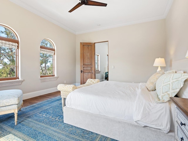 bedroom with baseboards, wood finished floors, a ceiling fan, and crown molding