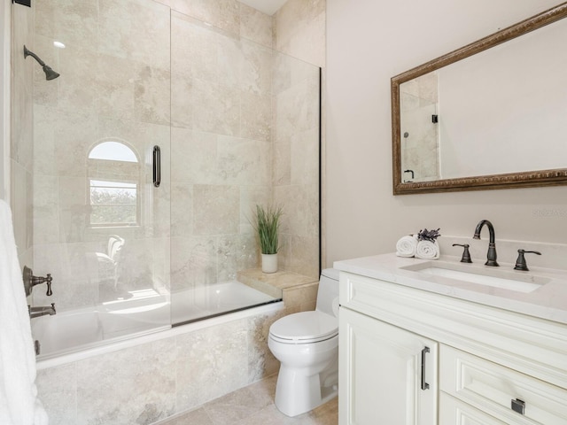 bathroom featuring toilet, tile patterned floors, tiled shower / bath, and vanity