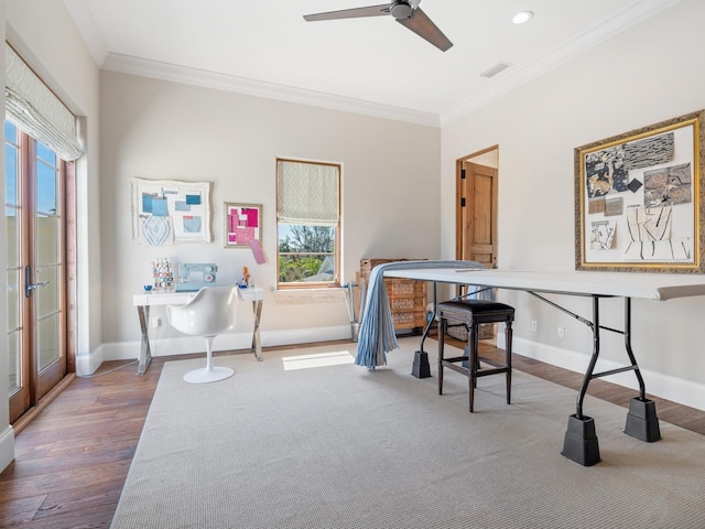 office featuring a ceiling fan, crown molding, baseboards, and wood finished floors