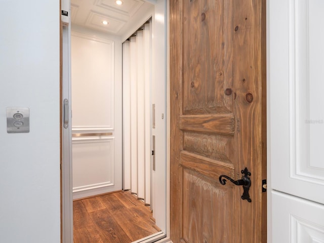 hallway with elevator, dark wood-type flooring, and recessed lighting