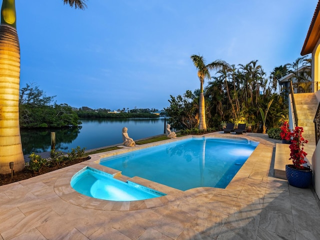 view of pool with a patio, a water view, and a pool with connected hot tub