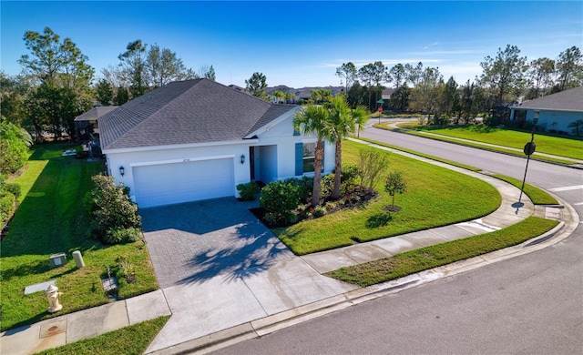 ranch-style home with roof with shingles, an attached garage, decorative driveway, a front lawn, and stucco siding