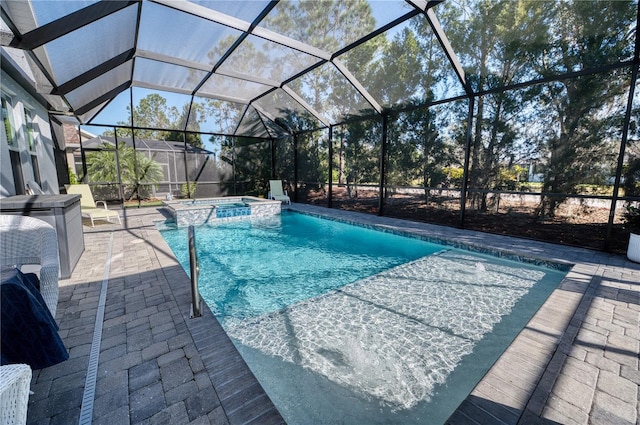 view of pool with a patio area, a lanai, and a pool with connected hot tub