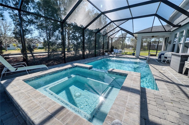 view of pool with a pool with connected hot tub, glass enclosure, and a patio