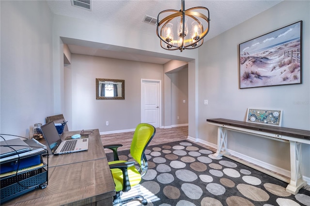 office space with an inviting chandelier, baseboards, visible vents, and a textured ceiling