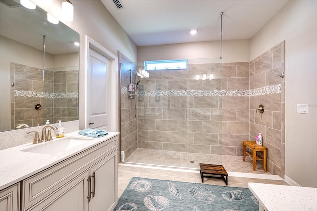 bathroom featuring visible vents, vanity, and walk in shower