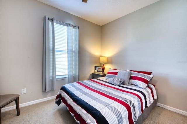 carpeted bedroom featuring multiple windows and baseboards