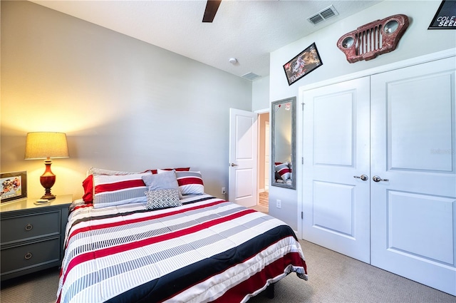 carpeted bedroom with ceiling fan, a closet, and visible vents