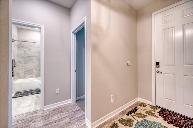 entryway with baseboards and wood finished floors