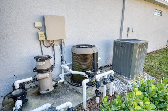 exterior details featuring central AC unit and stucco siding