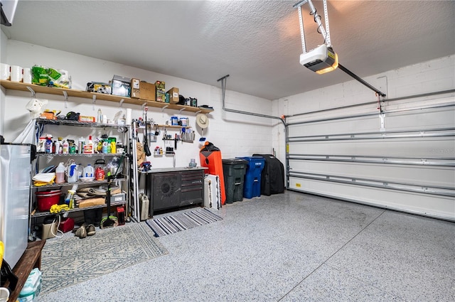 garage with a garage door opener and concrete block wall