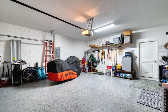 garage featuring electric panel, concrete block wall, and a garage door opener