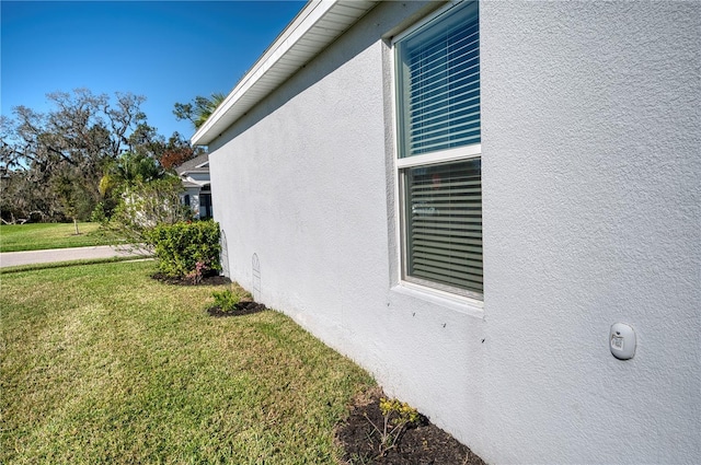 view of property exterior featuring a lawn and stucco siding