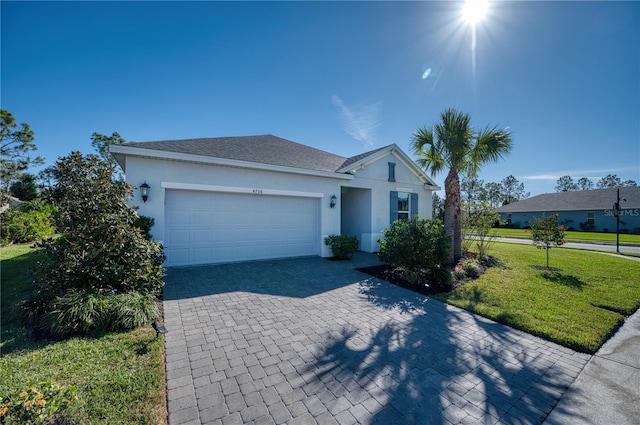 ranch-style home featuring decorative driveway, stucco siding, a shingled roof, a front yard, and a garage