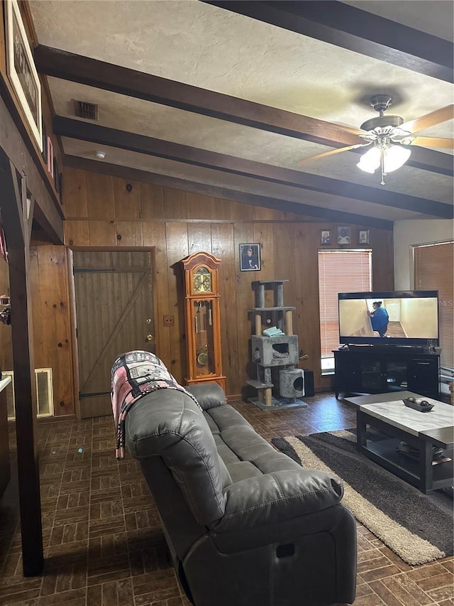 living room featuring brick floor, visible vents, beam ceiling, and wooden walls