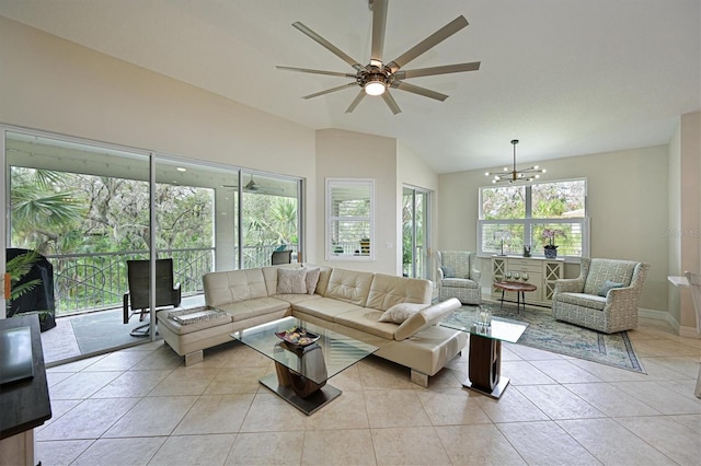 living room with lofted ceiling, light tile patterned floors, and ceiling fan with notable chandelier