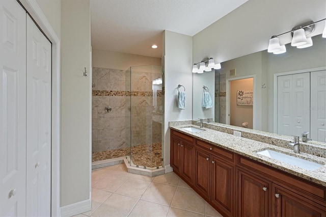 full bathroom featuring a closet, a sink, and tile patterned floors