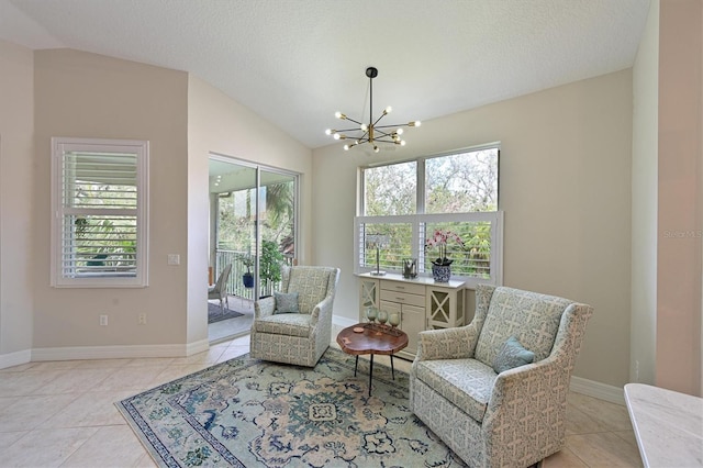 living area featuring plenty of natural light, a notable chandelier, and vaulted ceiling