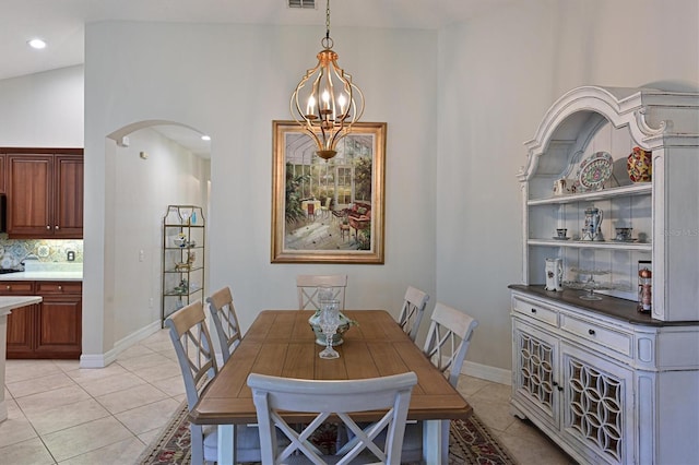 dining room featuring arched walkways, a notable chandelier, visible vents, light tile patterned flooring, and baseboards