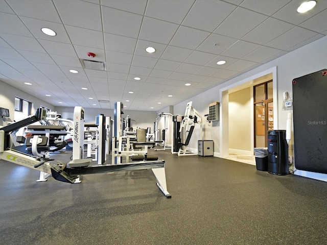 workout area with baseboards, a paneled ceiling, and recessed lighting