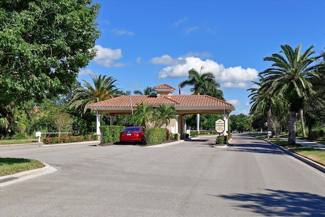 view of street with a gated entry and curbs