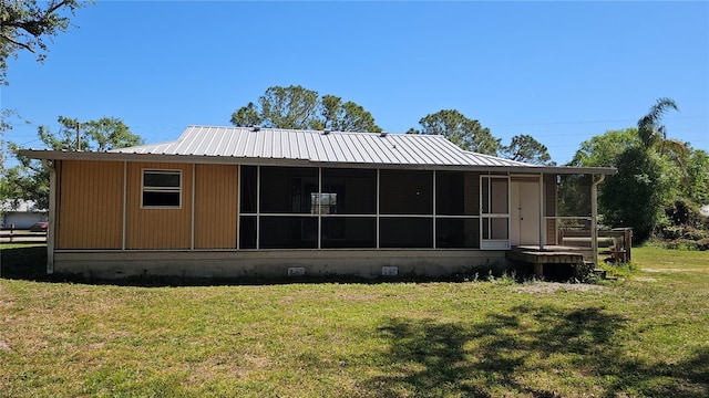 back of property with a yard, crawl space, and a sunroom